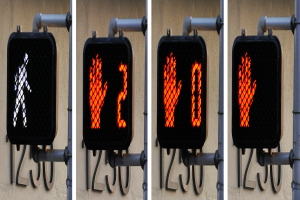 Eine an einem Gebäude angebrachte Ampel, die drei verschiedene Arten von Verkehrssignalen anzeigt.