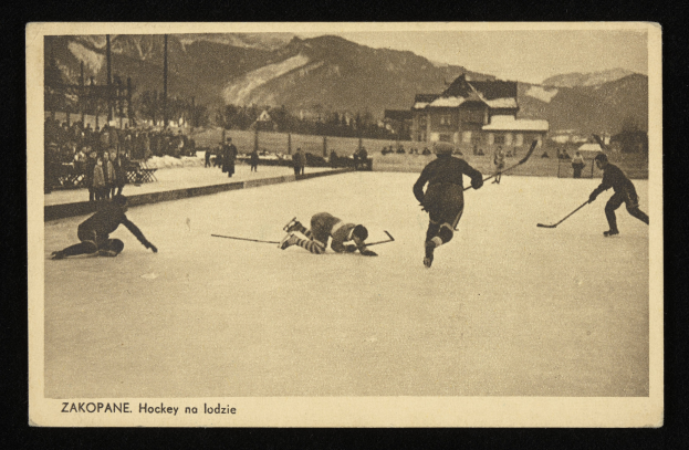 Ein altes Schwarz-Weiß-Foto von Menschen, die Hockey auf einem Eisring spielen, mit Gebäuden, Bäumen, Pfählen und Bergen im Hintergrund und Text unten.
