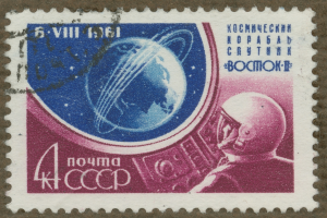 Eine Briefmarke mit einem Mann im Weltraumanzug mit Helm, der einen entschlossenen Gesichtsausdruck hat und von der fettgedruckten, weißen Schrift "Marke" umgeben ist.