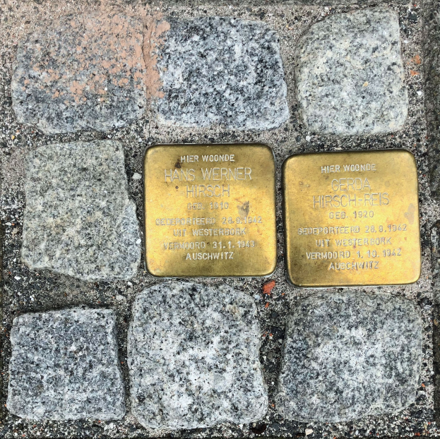 Drei Messingplaketten mit Inschrift in einem Kopfsteinpflaster eingelassen, wahrscheinlich zum Gedenken.