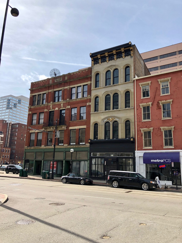 Eine Stadtstraße mit parkenden Autos, Laternen, Mülltonnen und Gebäuden unter einem bewölkten Himmel, mit einem Wasserzeichen für eine kommerzielle Immobilie an 715 N Main St, Chicago, IL 60611.