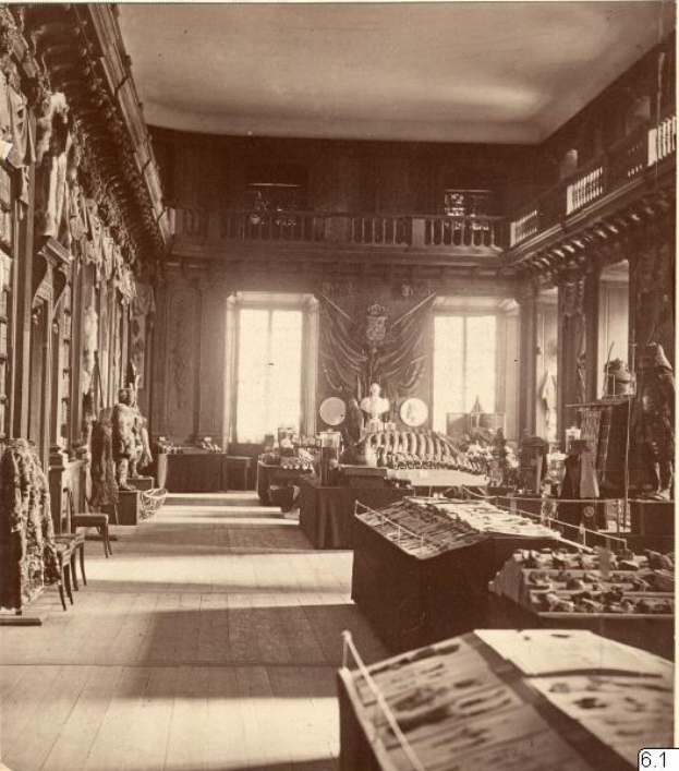 Schwarz-weiß-Foto eines Raums im Museum of Fine Arts, London, mit Tischen, Stühlen, Skulpturen an den Wänden, Fenstern mit Vorhängen und Geländern.