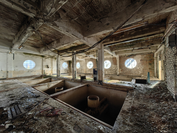 Verlassenes Gebäude im Innern der Sperrzone von Tschernobyl mit verstreuten Trümmern, freiliegenden Wänden, Decke und strukturellen Elementen.