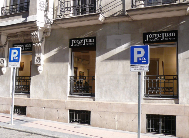 Ein mehrst├Âckiges Geb├Ąude mit Fenstern, Gel├Ąndern, Türen und S├Ąulen, das Schilder an Pfosten entlang des Gehwegs und einsehbare Innenobjekte aufweist, die auf eine belebte Stadtkulisse hindeuten.