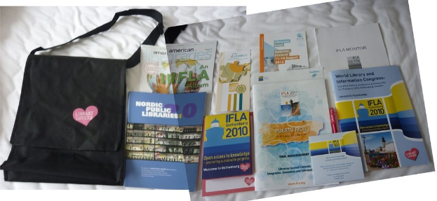 Eine Tasche mit 'Bibliotheksliebhaber' drauf und einige Bücher auf einem Bett.