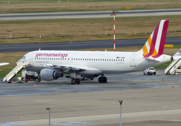 Germanwings Airbus A320-200 am Frankfurter Flughafen mit Fahrzeugen, Verkehrskegeln, Pfählen und Gras im Hintergrund.