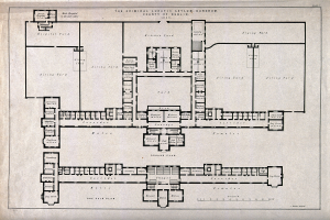 Schwarz-weißer architektonischer Grundriss eines großen Gebäudes mit zahlreichen beschrifteten Räumen, darunter ein 'Irrenhaus für Kriminelle', begleitet von handgeschriebenem Text, der das Layout beschreibt.