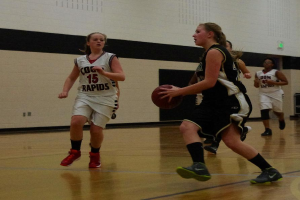Eine Gruppe von Menschen, die Basketball in einem Innenraum mit einer Wand im Hintergrund spielen.