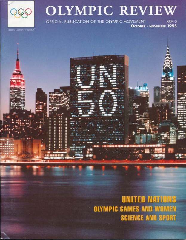 Ein Buch mit dem Titel "Olympic Review Official Publication of the Olympic Movement" liegt auf einer flachen Oberfläche, das eine Stadtlandschaft mit Gebäuden, Lichtern und Wasser auf dem Cover zeigt, mit dem Text "United Nations Olympic Games and Women Science and Sport" sichtbar.