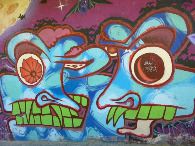 Ein leuchtendes, farbenfrohes Wandgemälde mit Graffiti-Kunst an der Seite eines Gebäudes.